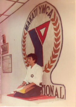 John A. Havan seated before the Makati YMCA emblem